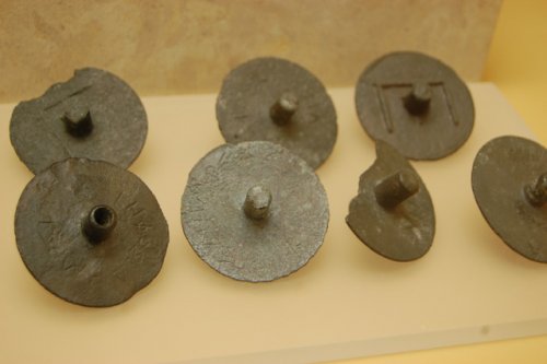 Chapas de bronze utilizadas nos tribunais gregos para votar pela culpa (com buraco no centro) ou inocência (centro sólido) do réu. Cerca de 300 a.C. Museu da Ágora de Atenas.